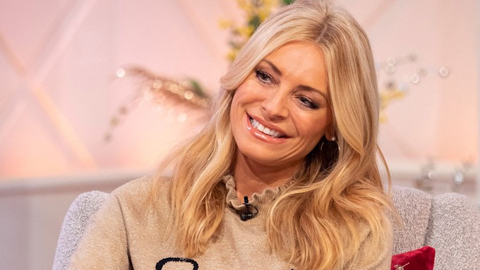 Tess Daly smiling in a beige cardigan
