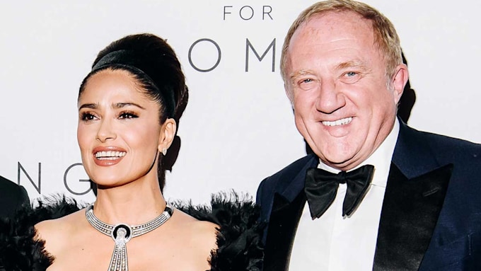 Salma and Francois-Henri smiling on a red carpet
