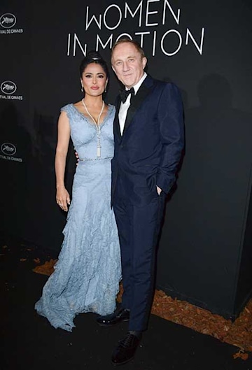 Salma and Francois-Henri standing together on a red carpet in Cannes