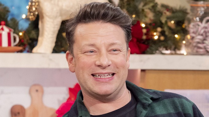 Jamie Oliver in a green check shirt smiling in a christmas setting