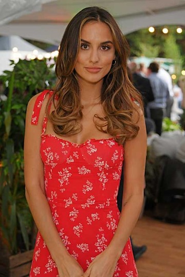 lucy wears a red strappy dress with bows and bronze fake body tan for a summery look as she poses for the camera