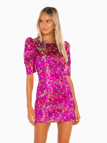 a model wears a pink satin mini dress which features shiny flower details and it has short sleeves and a fitted waistline just like kaleys valentino dress