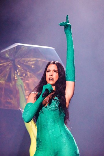 Dua Lipa wears a green bodysuit and matching green gloves