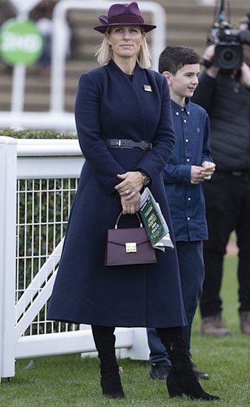 zara tindall at races wearing navy coat and knee high boots 