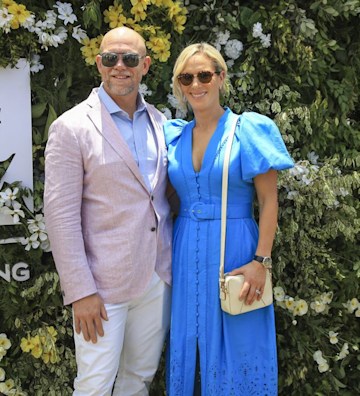Mike Tindall wears a pink linen suit and Zara Tindall wears a blue dress