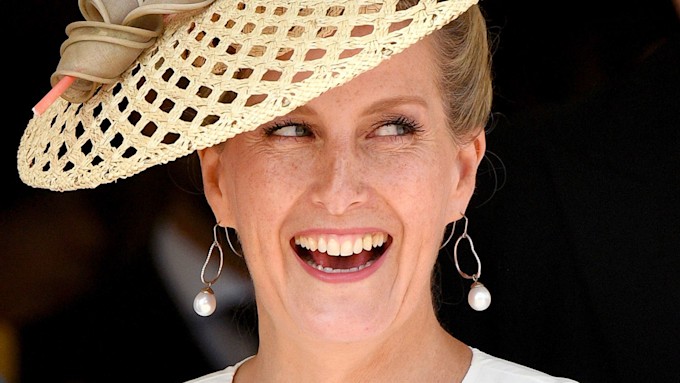 The Countess of Wessex smiles in a wicker hat and pear earrings