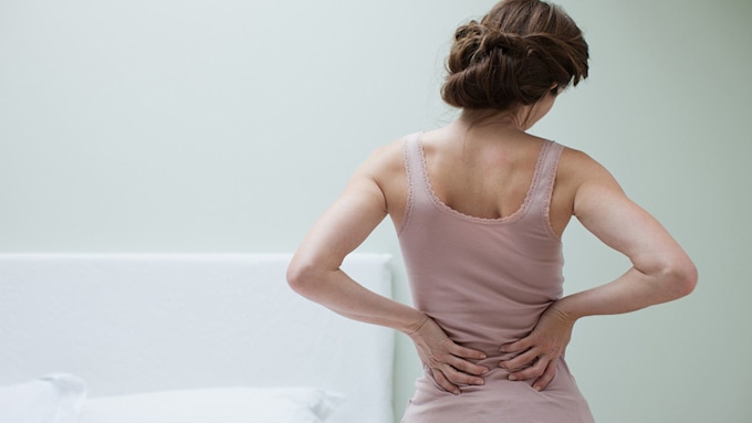 Woman holding her back in pain