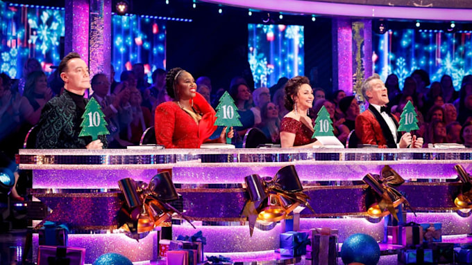 Strictly judges holding Christmas paddles