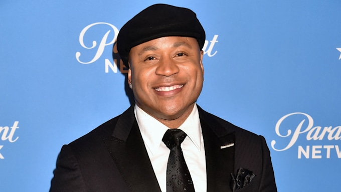 LL Cool J smiling. He is wearing a smart suit and a hat. 