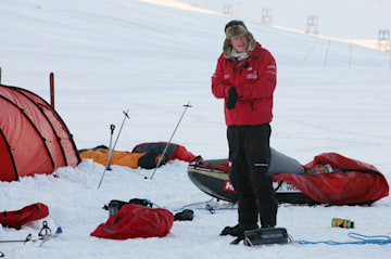 Prince Harry in a red jacket in Antarctica surrounded by tents