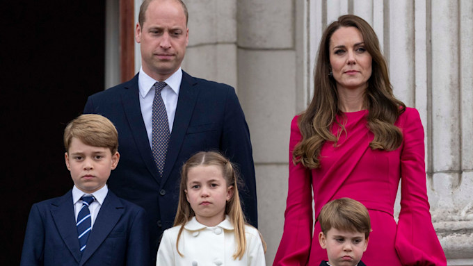 The Wales family looking serious on the Buckingham Palace balcony