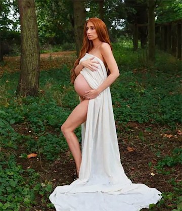 Pregnant Stacey Solomon poses in the woods in a flowing white gown that exposes her baby bump