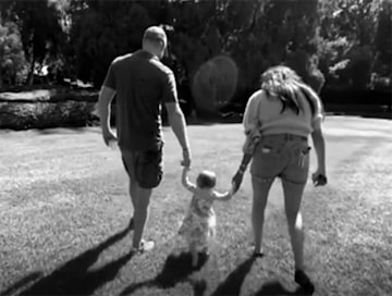 Lilibet walks with mum and dad in garden