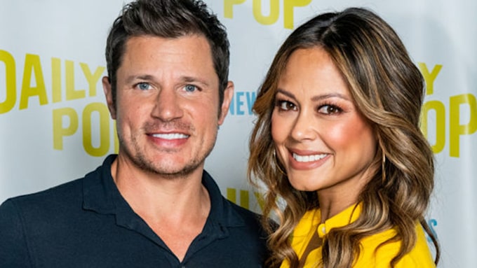 Vanessa Lachey and Nick Lachey cuddled up and smiling during a red carpet appearance. 