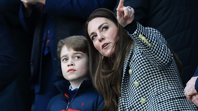 Princess Kate points up at the sky beside Prince George