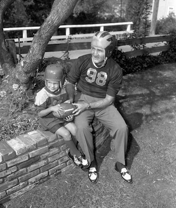 Tom Harmon wearing his 98 jersey as he sits with his son Mark in the garden. 