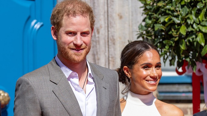 prince harry and meghan smiling in the sunshine 