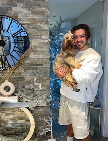 Jack Grealish holding his pet dog and showing off his home decor