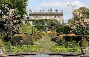 a house nestled in a garden which is in full bloom