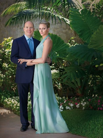 charlene looks beautiful in a mint green chiffon gown in a garden beneath palm trees as albert clutches her arm and smiles