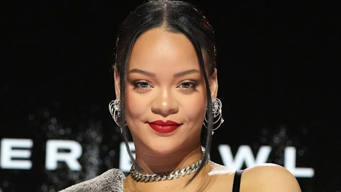 Rihanna smiling wearing red lipstick