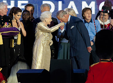 Prince Charles kisses the Queen's hand gold dress