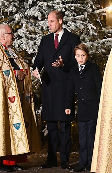 Prince William and Prince George in suits with a Christmas tree behind them