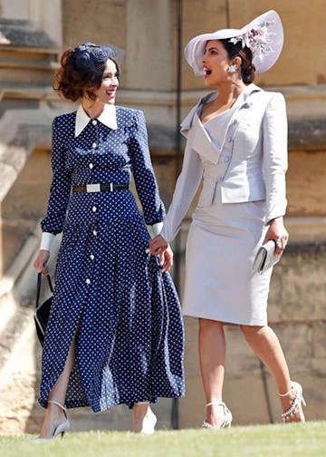 Abigail Spencer wearing a navy and white polka dot dress as she heads into St George's chapel with Priyanka Chopra in