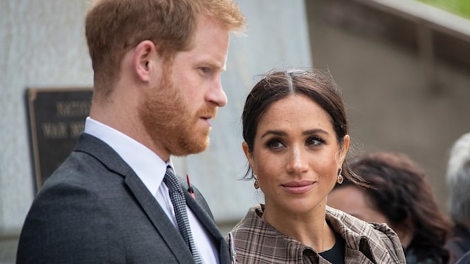 meghan markle looks up at concerned prince harry