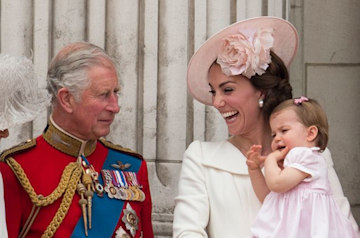 king charles looks at his granddaughter princess charlotte in the arms fof kate middleton on balcony of buckingham palace