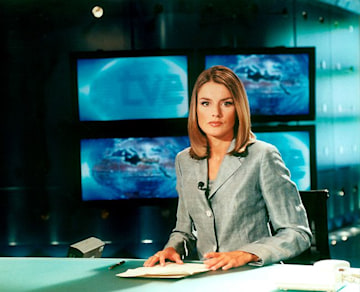 Quee Letizia pictured looking solemn as she prepares to read the news for TV