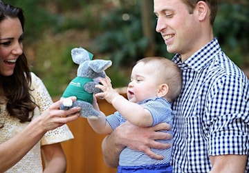 Prince William holding Prince George as Kate gives him a toy bilby during a visit to the Bilby Enclosure at Taronga Zoo